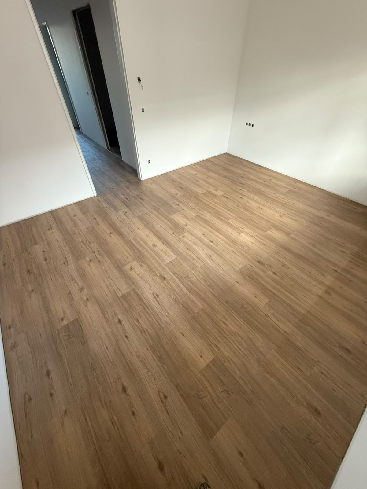 Helles Zimmer mit neu verlegtem Boden in Eichenoptik